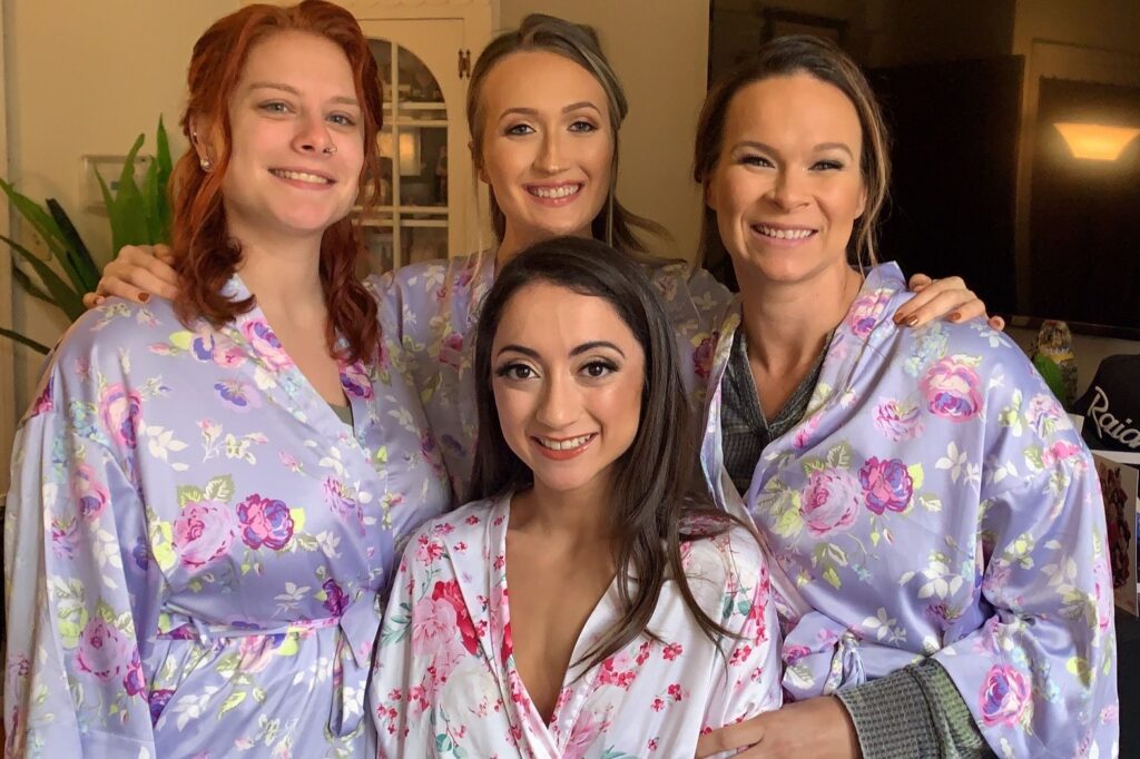 Tan bride posing with her bridesmaids on her wedding day